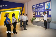 Du khách lắng nghe thuyết minh về vai trò lịch sử của Căn cứ Trung ương Cục miền Nam trong kháng chiến chống Mỹ. (Ảnh: Giang Phương/TTXVN)