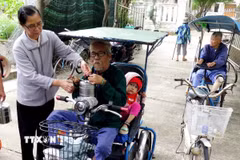 Sơ Hoàng Thị Mỹ Dung, Phụ trách Cộng đoàn Phanxicô Quy Hòa phát cơm miễn phí cho bệnh nhân phong lớn tuổi vào thứ 5 hàng tuần. (Ảnh: Lê Phước Ngọc/TTXVN)