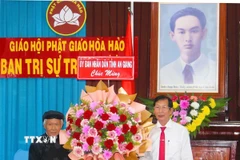 Phó Chủ tịch Ủy ban Nhân dân tỉnh An Giang Lê Văn Phước (phải) tặng hoa mừng Ban Trị sự Trung ương Giáo hội Phật giáo Hòa Hảo. (Ảnh: Công Mạo/TTXVN)