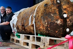 Hai chuyên gia xử lý bom mìn ngồi bên cạnh quả bom nặng 1,8 tấn thời Thế chiến 2, ngay sau khi họ vô hiệu hóa nó, tại Frankfurt, Đức năm 2017. (Nguồn: AP)