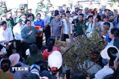 Thủ tướng Phạm Minh Chính thăm hỏi, động viên các hộ dân bị ảnh hưởng bởi triều cường tại xã Đề Gi. (Ảnh: Dương Giang/TTXVN)