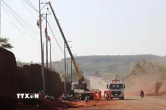 Cán bộ, công nhân điện lực Đồng Nai tiến hành di dời hơn 30 trụ điện phục vụ mở rộng tuyến đường ĐT.753. (Ảnh: Đậu Tất Thành/TTXVN)