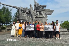 Gia đình nhà báo, liệt sỹ Lương Nghĩa Dũng tặng các nữ pháo thủ của Đại đội nữ pháo binh Ngư Thủy 2 bức ảnh tư liệu. (Ảnh: TTXVN phát)