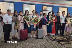 Bà Nguyễn Thị Kim Chung Phó Giám đốc sở Văn hóa Thể thao và Du lịch tỉnh Bình Định tặng hoa cho du khách. (Ảnh: Sỹ Thắng/TTXVN)