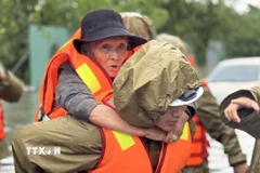Di dời kịp thời một người già phường Tuy Hoà đến nơi an toàn. (Ảnh: Tường Quân/TTXVN)
