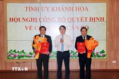 Ông Nghiêm Xuân Thành, Bí thư Tỉnh ủy Khánh Hòa trao quyết định và tặng hoa chúc mừng Chủ tịch và Phó Chủ tịch Hội đồng Nhân dân tỉnh. (Ảnh: Công Thử/TTXVN)