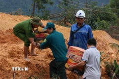 Tuyến Quốc lộ 40B bị sạt lở nặng, tuyến đường nối từ vùng đồng bằng về nhiều khu vực miền núi bị đình trệ hoàn toàn, hàng hóa tiếp tục được vận chuyển bằng sức người. (Ảnh: Đoàn Hữu Trung/TTXVN)