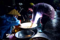 Ở "chợ ma" Tha La, mỗi người đều mang theo chiếc đèn pin để thuận lợi cho việc mua bán. (Ảnh: Công Mạo/TTXVN)