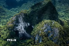Núi đá vôi karst tại Phong Nha-Kẻ Bàng với các cửa hang lớn mở ra giữa rừng nguyên sinh, phản ánh quá trình kiến tạo địa chất kéo dài hàng triệu năm. (Ảnh: Kha Phạm/TTXVN)