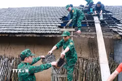 Lực lượng Đồn Biên phòng Tùng Vài (Tuyên Quang) giúp người dân lợp lại mái nhà cho người dân bị ảnh hưởng của mưa đá, dông lốc. (Ảnh: Đức Thọ/TTXVN)