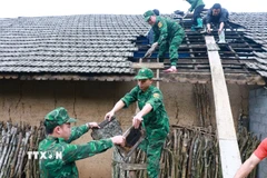 Lực lượng Đồn Biên phòng Tùng Vài (Tuyên Quang) giúp người dân lợp lại mái nhà cho người dân bị ảnh hưởng của mưa đá, dông lốc. (Ảnh: Đức Thọ/TTXVN)