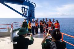 Hình ảnh cờ Tổ quốc trở thành cầu nối giữa đất liền và biển đảo. (Ảnh: Xuân Quý/TTXVN)