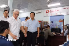 Bí thư Tỉnh ủy Bình Dương Nguyễn Văn Lợi kiểm tra giải quyết thủ tục hành chính tại bộ phận một cửa. (Ảnh: Văn Hướng/TTXVN)