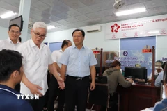 Bí thư Tỉnh ủy Bình Dương Nguyễn Văn Lợi kiểm tra giải quyết thủ tục hành chính tại bộ phận một cửa. (Ảnh: Văn Hướng/TTXVN)