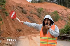 Lực lượng túc trực hàng ngày để cảnh báo, điều tiết các phương tiện trong quá trình thi công khắc phục sạt lở. (Ảnh: Nguyễn Dũng/TTXVN)