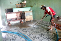 Người dân phường Hàm Thắng (Lâm Đồng) dọn dẹp nhà cửa sau lũ. (Ảnh: Nguyễn Thanh/TTXVN)