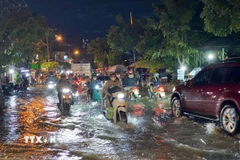 Các phương tiện di chuyển khó khăn khi triều cường gây ngập trên đường Trần Xuân Soạn (Quận 7, Thành phố Hồ Chí Minh). (Ảnh: Hồng Giang/TTXVN) 