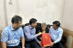 Thường trực Ban Bí thư Trần Cẩm Tú (đầu tiên, phải sang) thăm, tặng quà gia đình chính sách tại thành phố Huế bị ảnh hưởng mưa lũ. (Ảnh: Mai Trang/TTXVN)