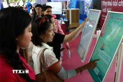 Người dân Thành phố Hồ Chí Minh trải nghiệm các dịch vụ trong khuôn khổ Lễ hội Không tiền mặt 2025. (Ảnh: Hứa Chung/TTXVN)