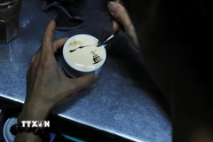 Người pha chế trang trí cho ly càphê trứng với hình ảnh Tháp Rùa. (Ảnh: Lâm Khánh/ TTXVN)