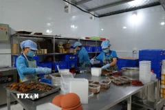 Công nhân chuẩn bị cá mòi kho làng Chài cho dịp Tết. (Ảnh Tiến Vĩnh/TTXVN)