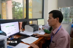 Cán bộ Tư pháp-Hộ tịch Ủy ban Nhân dân Phường 2, thành phố Tuy Hòa giải quyết thủ tục hành chính cho công dân. (Ảnh: Xuân Triệu/TTXVN)