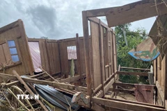 Một phần ngôi nhà bị lât ngược do nước lũ cuốn. (Ảnh: Văn Tý/TTXVN)
