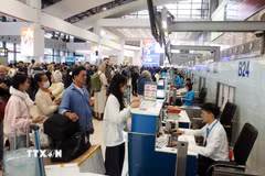 Hành khách xếp hàng làm thủ tục tại sân bay Nội Bài. (Ảnh: Quốc Khánh/TTXVN)