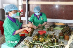 Người lao động làm bánh tét tại cơ sở sản xuất bánh tét Ba Loan, làng nghề bánh tét Trà Cuôn. (Ảnh: Thanh Hòa/TTXVN)