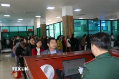 Du khách xếp hàng chờ làm thủ tục xuất nhập cảnh qua cửa khẩu Quốc tế Lào Cai. (Ảnh Hồng Ninh/TTXVN)