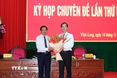Bí thư Tỉnh ủy Vĩnh Long Trần Văn Lâu tặng hoa chúc mừng ông Trần Trí Quang được bầu giữ chức Chủ tịch Ủy ban Nhân dân tỉnh Vĩnh Long. (Ảnh: Phạm Minh Tuấn/TTXVN)