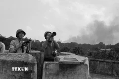 Trên đỉnh nóc nhà số 18 Trần Hưng Đạo, phóng viên ảnh Việt Nam Thông tấn xã săn máy bay Mỹ cháy trên bầu trời Hà Nội trong 12 ngày đêm B52 Mỹ đánh phá Hà Nội-Hải Phòng (trận Điện Biên Phủ trên không). (Ảnh: TTXVN)