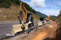 Công nhân hoàn thiện các hạng mục lan can, dải phân cách và biển báo trên tuyến cao tốc La Sơn Hòa Liên. (Ảnh: Xuân Quý/TTXVN)