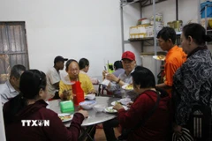 Những người dân đến ăn cơm chay tại chùa Tổ đình Nghĩa Phương. (Ảnh: Phan Sáu/TTXVN)