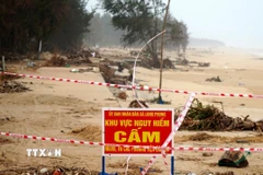 Chính quyền địa phương cắm biển cảnh báo nguy hiểm để người dân chú ý khi qua lại khu vực sạt lở. (Ảnh: Lê Phước Ngọc/TTXVN)