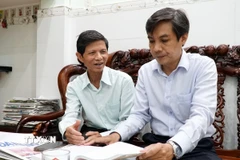 Ông Phạm Công Lương, Bí thư Chi bộ Khu dân cư Bình Phước 1, phường Hải Châu, thành phố Đà Nẵng (bên trái) chia sẻ cảm nhận về dự thảo Văn kiện Đại hội với cán bộ phường Hải Châu. (Ảnh: Quốc Dũng/TTXVN)