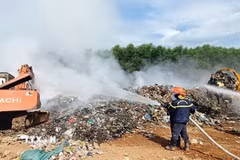 Các lực lượng chức năng đang tập trung nhân lực và phương tiện dập lửa tại Khu xử lý rác Trường Thủy. (Ảnh: TTXVN phát)