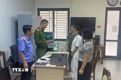 Kiểm sát viên Viện Kiểm sát Nhân dân tỉnh Thanh Hóa kiểm sát việc tống đạt Quyết định khởi tố và Lệnh tạm giam đối với bị can Trịnh Thị Vân Anh và Nguyễn Thị Thanh Ngần. (Ảnh: TTXVN phát)