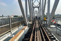 Công nhân đường sắt nỗ lực khắc phục sự cố cầu Ghềnh sau khi xảy ra tai nạn khiến tuyến đường sắt Bắc-Nam gián đoạn. (Ảnh: Sỹ Tuyên/TTXVN)