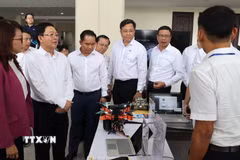 Phó Thủ tướng Chính phủ Hồ Quốc Dũng tham quan một số mô hình công nghệ mới tại Trường Đại học Quốc gia Thành phố Hồ Chí Minh. (Ảnh: Hứa Chung/TTXVN)