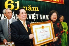 Phó Chủ tịch nước Trương Mỹ Hoa trao Huân chương Lao động hạng Nhì tặng Phó Tổng Giám đốc Thông tấn xã Việt Nam Trương Đức Anh nhân dịp kỷ niệm 61 năm Ngày truyền thống Thông tấn xã Việt Nam, tháng 9/2006. (Ảnh: TTXVN)