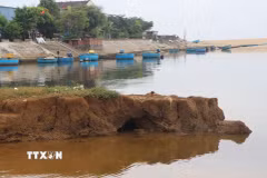 Những khối đất lớn liên tục bị cuốn trôi xuống lòng sông. (Ảnh: Đinh Hương/TTXVN)