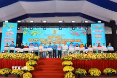 Ông Nguyễn Đình Khang, Chủ tịch Tổng Liên đoàn Lao động Việt Nam và ông Nguyễn Phước Lộc, Phó Bí thư Thành ủy Thành phố Hồ Chí Minh trao tặng vé máy bay cho công nhân lao động về quê đón Tết. (Ảnh: Thanh Vũ/TTXVN)