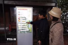 Du khách sử dụng hệ thống kiosk để tìm hiểu thông tin về di tích Đền Ông Hoàng Mười. (Ảnh: Bích Huệ/TTXVN)