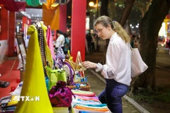 Du khách nước ngoài tham quan các sản phẩm tại gian trưng bày của làng lụa Vạn Phúc. (Ảnh: Khánh Hòa/TTXVN)