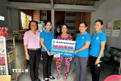 Chị Đặng Thị Huê, vượt khó nuôi con học đại học, nhận vốn cho vay của Hội Liên hiệp Phụ nữ xã Long Cang, tỉnh Tây Ninh. (Ảnh: Đức Hạnh/TTXVN)