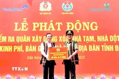 Trung tướng Phạm Thế Tùng, Ủy viên Ban Thường vụ Đảng ủy Công an Trung ương, Thứ trưởng Bộ Công an trao biểu trưng hỗ trợ kinh phí xóa 500 căn nhà tạm, nhà dột nát cho tỉnh Đắk Nông. (Ảnh: TTXVN phát)