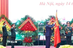Tổng Bí thư Tô Lâm gắn Danh hiệu Anh hùng Lực lượng vũ trang Nhân dân lên Quân kỳ Quyết thắng của Tổng cục Hậu cần-Kỹ thuật. (Ảnh: Thống Nhất/TTXVN)