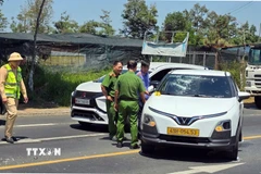 Cơ quan chức năng khám nghiệm hiện trường vụ việc đối tượng đập phá chiếc xe taxi do mâu thuẫn gia đình tại phường B'Lao. (Ảnh TTXVN phát)