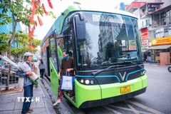 Hành khách lên xe buýt điện tại đường Cầu Giấy. (Ảnh: Hoàng Hiếu/TTXVN)